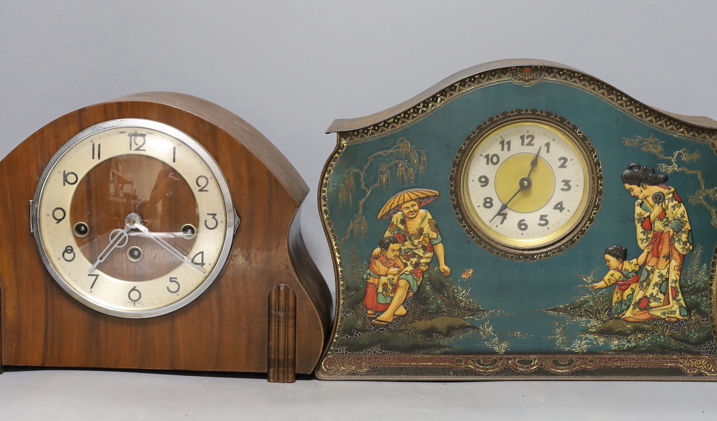 A tin mantel clock and 3 wooden clocks, 2 dog door stops and a blue and white plate.